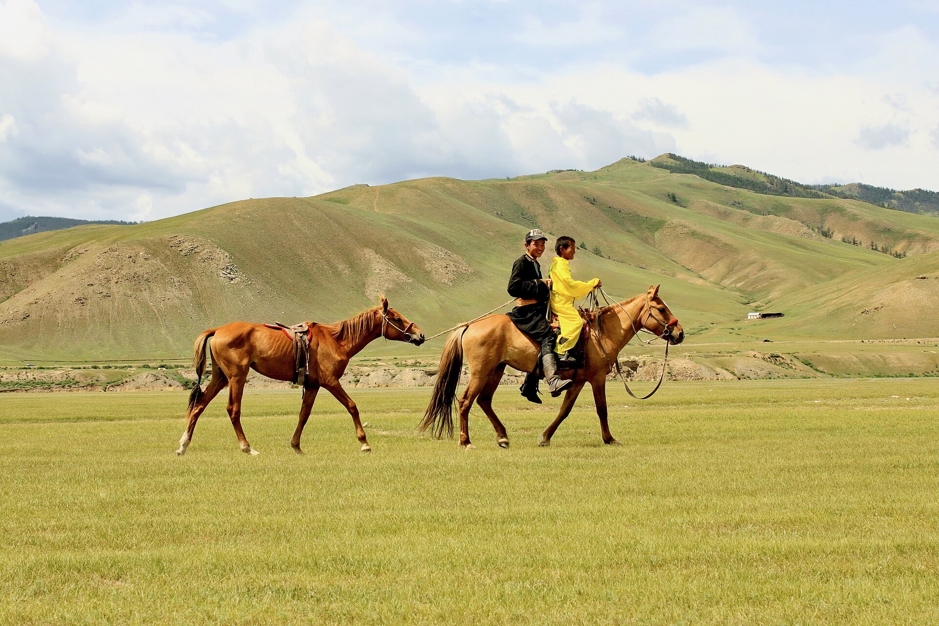 Mounted herders crossing the Mongolian steppe.