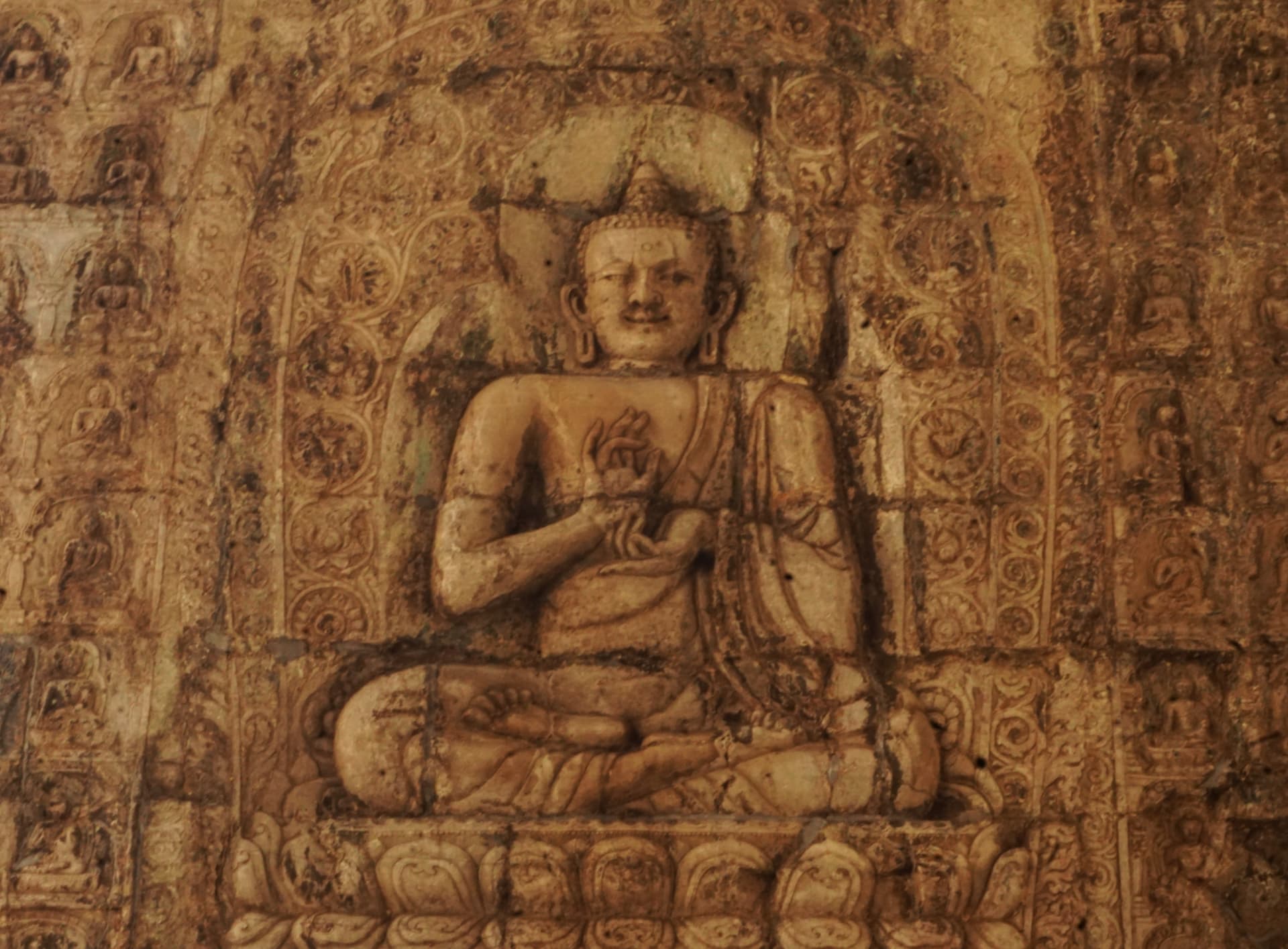 An ancient seated Buddhist figure painted on a cave wall in west China.